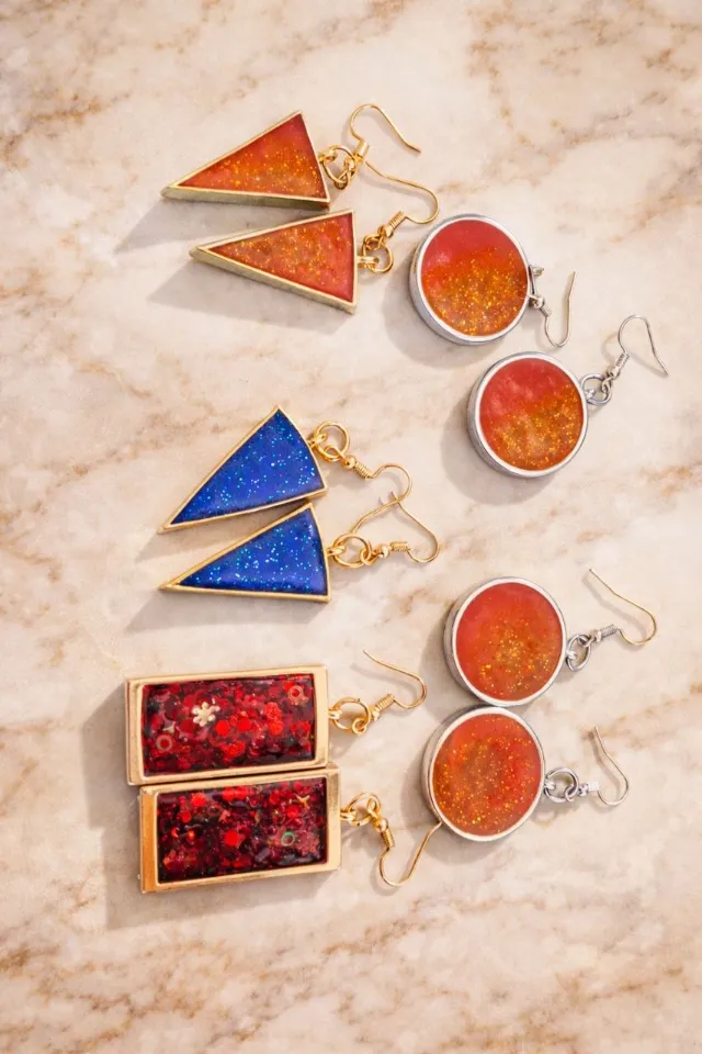 Matching pairs of triangle, round and rectangle glitter earrings on marble